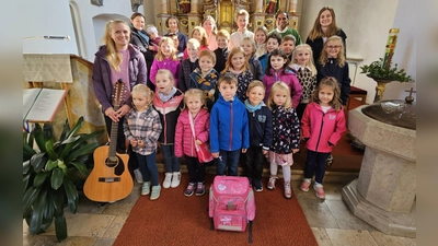 Symbolisch gepackt für den Lebensweg: Kinder zeigten beim Familiengottesdienst, was im „besonderen Ranzen“ nicht fehlen darf – Liebe, Trost, Mut und der Glaube an Gott. (Bild: Birgit Koppmann)