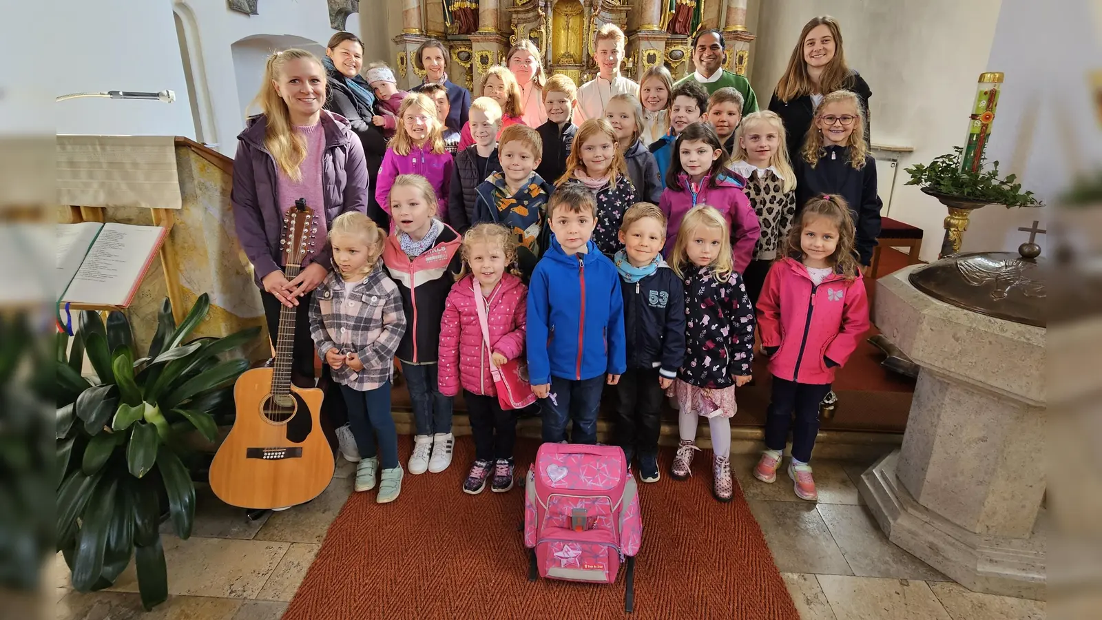 Symbolisch gepackt für den Lebensweg: Kinder zeigten beim Familiengottesdienst, was im „besonderen Ranzen“ nicht fehlen darf – Liebe, Trost, Mut und der Glaube an Gott. (Bild: Birgit Koppmann)