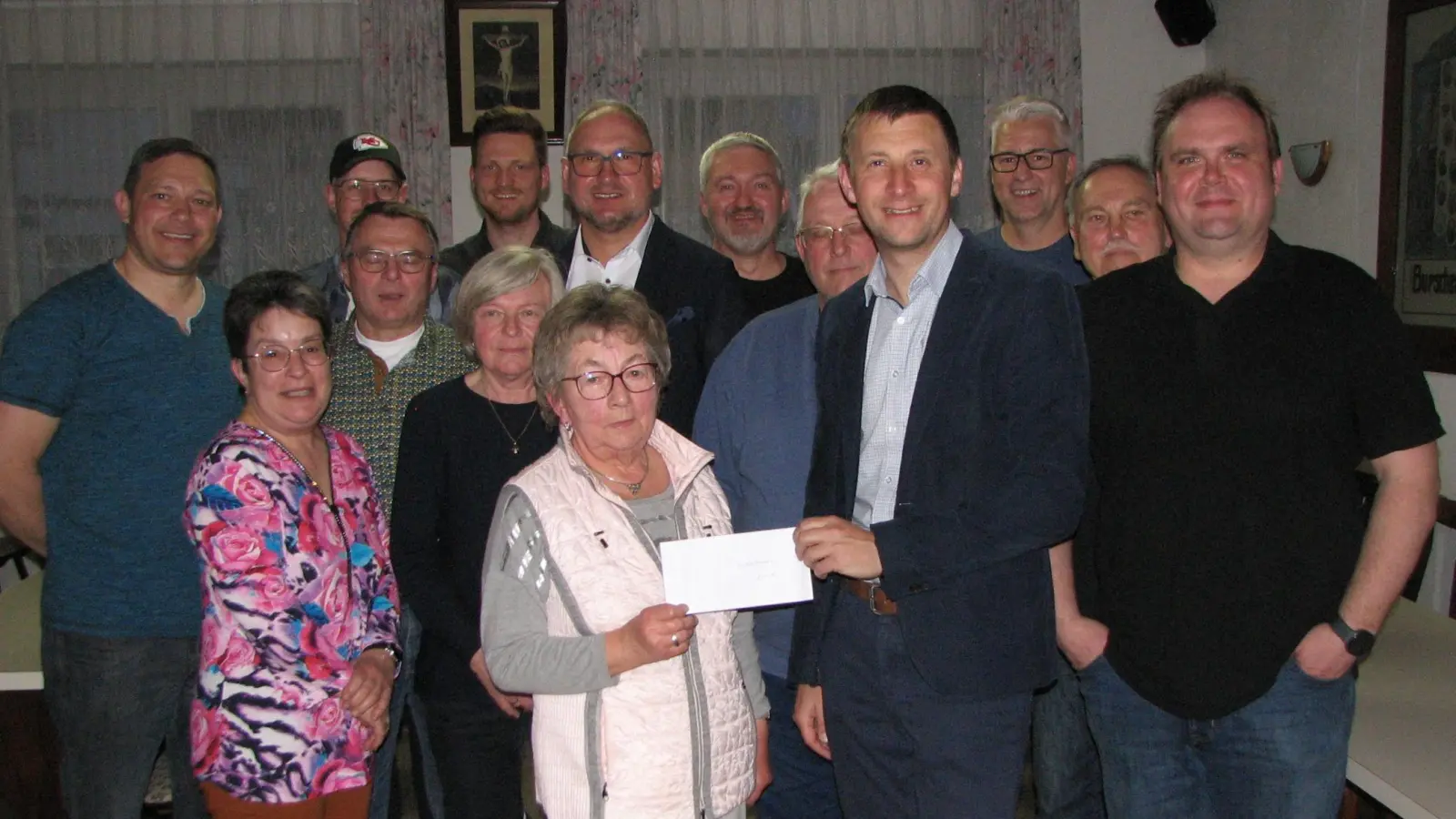 Vorsitzender Johannes Wittmann (vorne Zweiter von rechts) überreicht eine Geldspende an Sieglinde Wolfinger (vorne Zweite von links) von den Siedlerfrauen. Laut Bürgermeister Richard Kammerer (Bildmitte) ist die Siedlergemeinschaft ein wichtiger Aktivposten in der Marktgemeinde.  (Bild: Johann Kneißl)