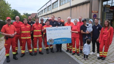 DLRG-Vorsitzender Gerhard Schottenheim (Sechster von rechts) nahm den Scheck aus der Hand von Club-Schatzmeister Stefan Fuchs entgegen. (Bild: Hubert Uschald)