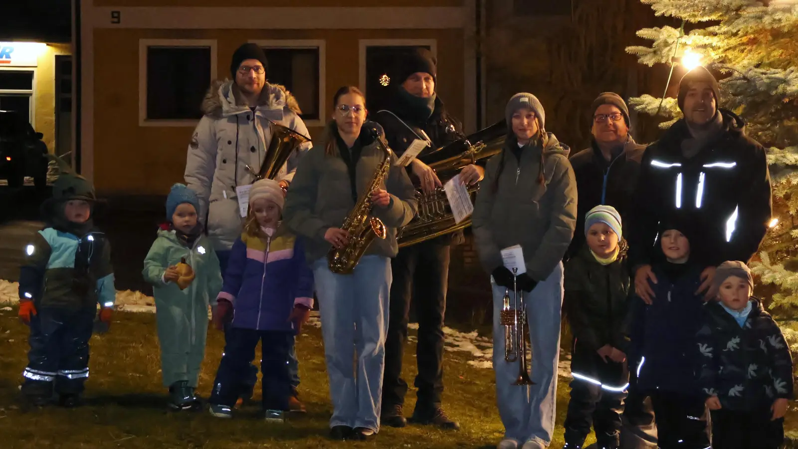 In Adlholz wird die Adventszeit eingeläutet und der Dorfchristbaum erstrahlt wieder. Darüber freuten sich, von links nach rechts: Michael Luber, Nadine Winklmann, Christian Winklmann, Jasmin Winklmann, Markus Rauscher und Matthias Köstler sowie auch die Adlholzer Kinder. (Bild: Markus Rauscher)