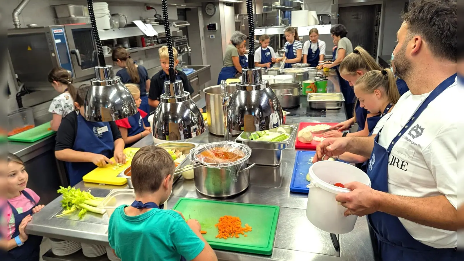 Christian Fleischmann, als Leiter des Kurses (rechts) beobachtet das vielfältige Geschehen, rund um den Kochbereich, in der Küche des Landhotels Weißes Roß (Bild: Norbert Weis)