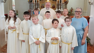 Neun Kinder aus der Schule im Heilpädagogischen Zentrum Irchenrieth feierten mit Pfarrer i.R. Alfons Forster (im Bild hinten) in der Pfarrkirche in Michldorf Erstkommunion. Auf diesen festlichen Tag wurden die Mädchen und Buben in der Schule von der Religionslehrerin Eva Wagner (rechts) sowie Lehrkräften und Betreuern der Schule bestens vorbereitet. (Bild: Albert Gruber)