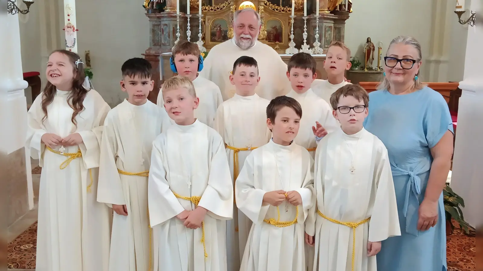 Neun Kinder aus der Schule im Heilpädagogischen Zentrum Irchenrieth feierten mit Pfarrer i.R. Alfons Forster (im Bild hinten) in der Pfarrkirche in Michldorf Erstkommunion. Auf diesen festlichen Tag wurden die Mädchen und Buben in der Schule von der Religionslehrerin Eva Wagner (rechts) sowie Lehrkräften und Betreuern der Schule bestens vorbereitet. (Bild: Albert Gruber)