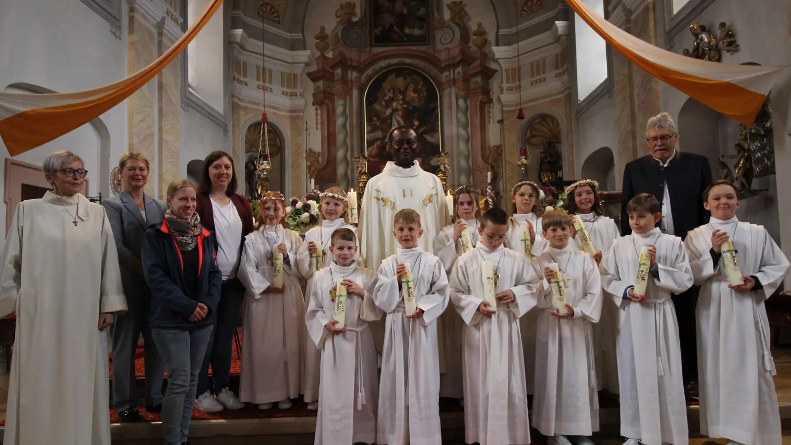 Bild von links nach rechts hinten: Gemeindereferentin Sabine Schiml, Rektorin Karin Gleißner, Veronika Richter (Religionslehrerin) Lisa Lehmann (Klassenlehrerin), Emma Köhler, Klara Führlich, Pfarrer George Emeka Oranekwu, Emily Korndörfer, Mia Grillmeier, Mesner Wolfgang Plonner, (zweite Reihe links:) Martin Stock, Paul Riolfi, Alan Jarzebac, Simon Altenöder, Fabian Franz, Anton Lang  (Bild: Sebastian Summerer)