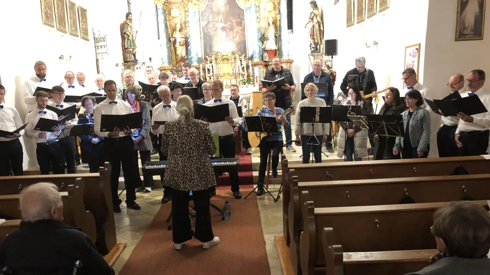 Mit einem gemeinsamen Lied beschlossen der MGV Schlicht (in weißen Hemden) und der Chor Grenzenlos unter der Leitung von Saskia Krügelstein das begeisternde Kirchenkonzert. (Bild: ct)