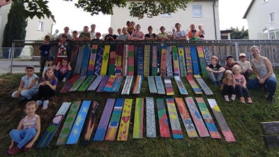 Die Kinder freuen sich über ihre farbenfrohen Zaunlattenkunstwerke.  (Bild: Monika Schultes)
