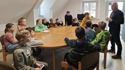 Bürgermeister Bindl erklärte den Viertklässlern die Bedeutung der Amtskette und überraschte die Kids damit, dass diese jeder mal anfassen und sogar einmal umhängen durfte.  (Bild: Tina Körner)