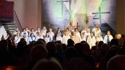 Das Bild zeigt die beleuchtete Kirche samt Gospelchor Voices of Joy. (Bild: Gerd Hennecke)
