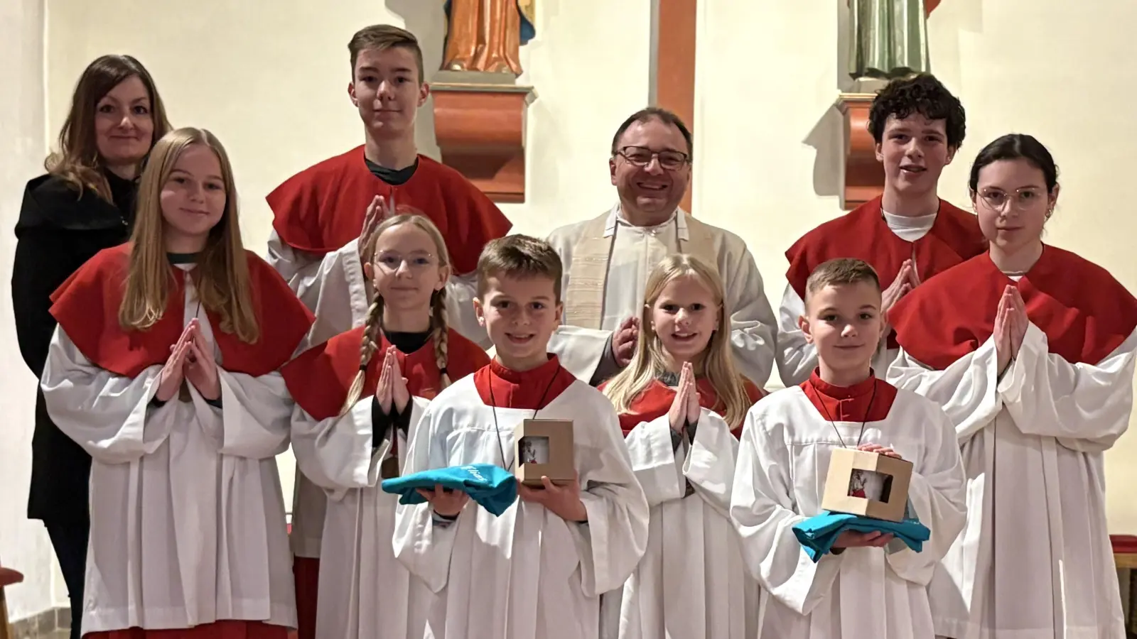 Jeweils ein kleines Präsent erhielten die beiden neuen Ministranten der Herz-Jesu-Pfarrei aus den Händen von Pfarrer Markus Bruckner und Pfarrgemeinderatsmitglied Maria Bock. (Bild: Kewog Siegert)