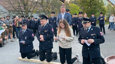 Die Bittsteller der Freiwilligen Feuerwehr Utzenhofen kniend auf den Holzscheit (Bild: Franziska Lorenz)