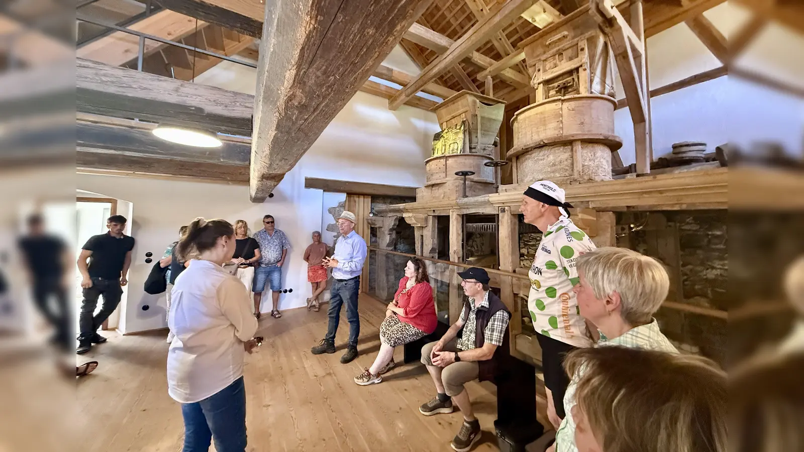 Dr. Martin Nagler (mit Strohhut) führte die Besucher durch die hsitorische Mühle. Der Balken, der sich quer durch den Raum zieht, ist mehr als 300 Jahre alt. (Bild: Ina Piehler)