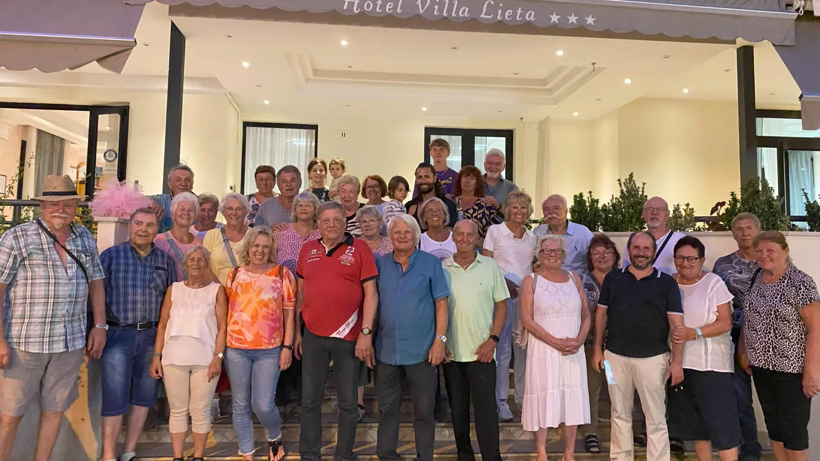 Das Foto zeigt einen Teil der Reisenden vor dem Hotel Villa Lieta (oben in der Mitte Hotelchefin Monica mit ihrem Enkel Matteo, rechts daneben ihr Sohn und Bademeister Diego mit Thomaso) (Bild: Heribert Ficker)