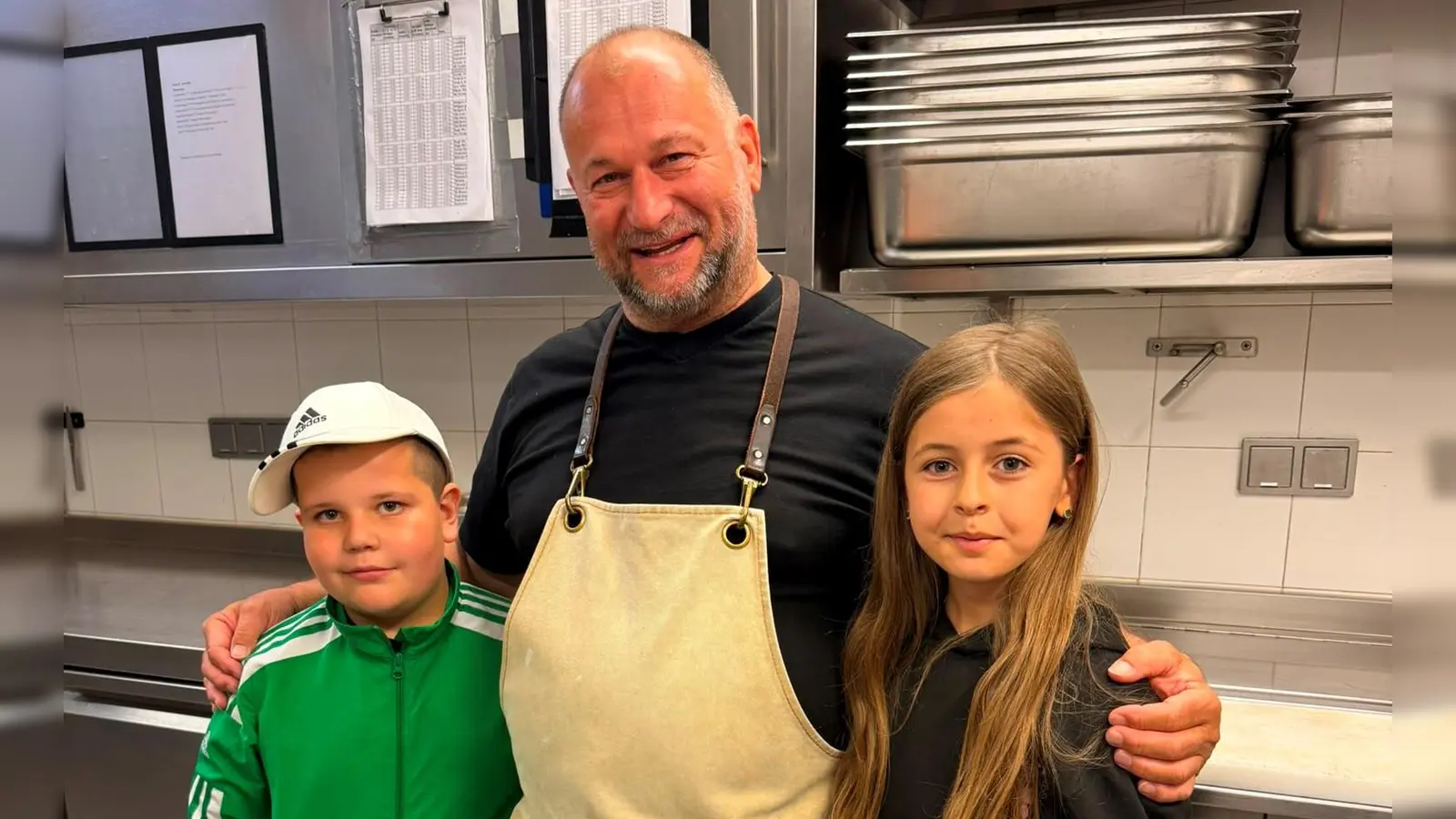 Michael Heumann mit zwei Hortkindern während der Führung durch die Küche. (Bild: Helena Brozmann)