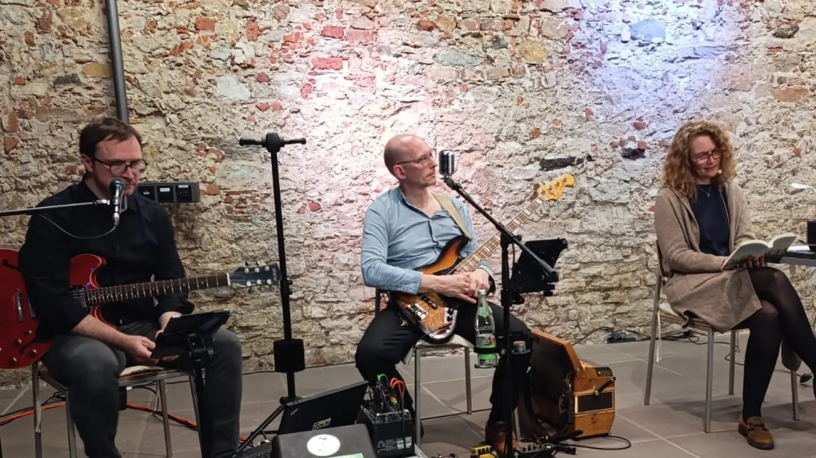 Die Autorin Gerda Stauner (rechts) las bei der Auftaktveranstaltung zum 40. Jubiläum der Stadt- und Pfarrbücherei aus ihrem neuen Roman. Die Musiker Adi Spangler und Manfred Mederer begleiteten sie zu den Klängen von Elvis Presly.  (Bild: Jonas Dittrich)