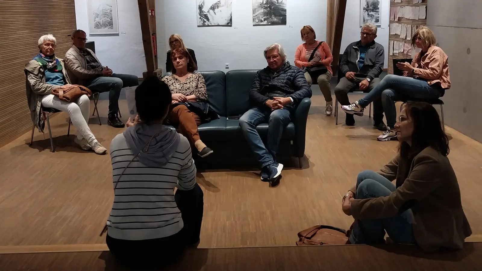 Jiaying Wu (vorne li.) erklärte ihren Gästen aus Tirschenreuth im Kunsthaus, wie sie im Fluss Wondreb stehend mit Reispapier und Tusche Kunstwerke auf das Papier zaubert. In einer Ausstellung der Chinesin konnten sich die KVT-Mitglieder dann vor Ort von der Qualität und Schönheit dieser Wasser-Malereien überzeugen.  (Bild: Ulla Britta Baumer)