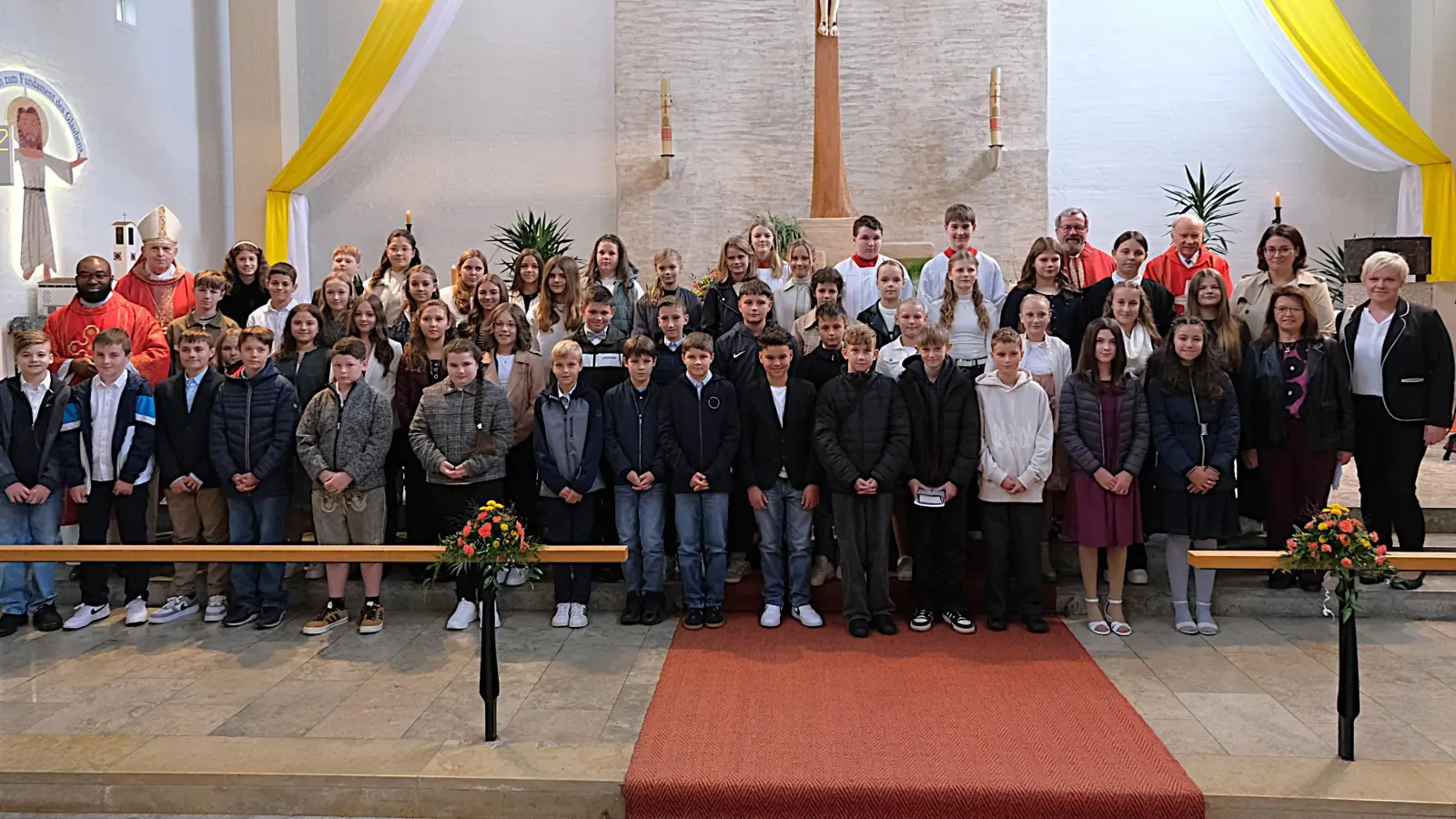 53 Firmlinge mit von links Pfarrvikar Bonaventure Ukatu, Weihbischof Reinhard Pappenberger mit in der Mitte hinten den 3 Ministranten, Pfarrer Markus Ertl, Ruhestandsgeistlicher Hans-Peter Bergmann, rechts aussen das Firmteam Judith Kiener, Justina Filipiak, Maria Schlögl (Bild: Toni Wild)