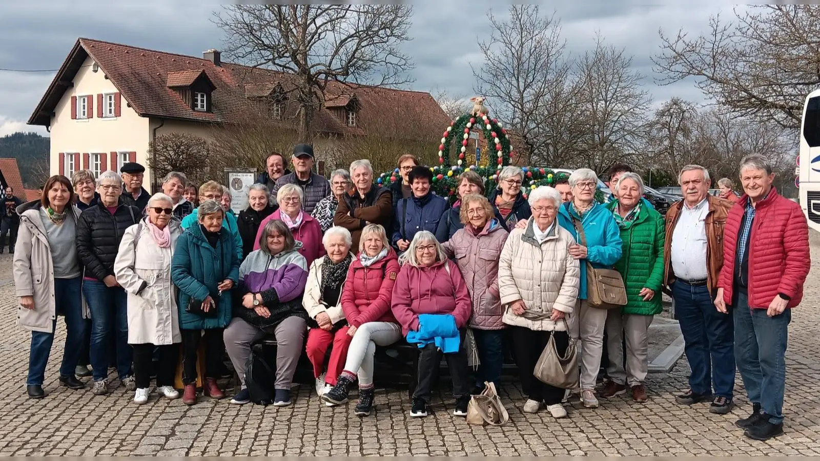 Die Teilnehmenden des AWO‑Ausflugs vor dem österlich geschmückten Brunnen in Hohenberg an der Eger. (Bild: Johann Völkl)