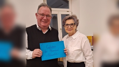 Hildegard Gallitzendörfer überreicht symbolisch den Zuschuss für eine verbesserte Akkustik im Pfarrsaal. Pfarrer Michael Birner strahlt sichtlich.  (Bild: Margarete Hirsch)