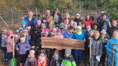 Die Mädchen und Buben der Grundschule pflanzten unter Anleitung von Karl-Heinz Melzer (Zweiter von rechts), Carina Czurda (rechts) und Meinhard Köstler (links) unterschiedliche Baumarten. Danach gab's eine Brotzeit. (Bild: lym)