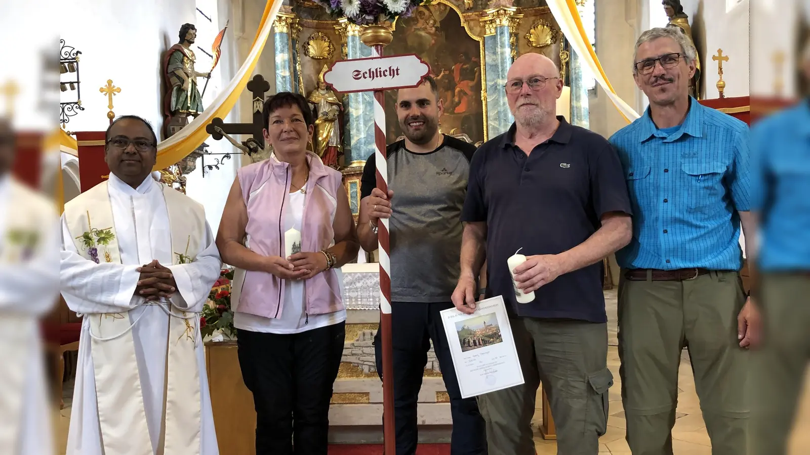 Bereits in der Basilika Gößweinstein wurden nach dem Wallfahreramt für ihre „Jubiläums-Teilnahme“ Georg Denninger für 50 und Maria Hefner für 10 Wallfahrten mit einer Urkunde ausgezeichnet und in Schlicht erhielten sie von Pilgerführer Edmund Heldmann (rechts) die neugestaltete Kerze. Dazu gratulierten auch Pfarrer Hruday Madanu und Wallfahrtsbild-Träger Stefan Wismeth.  (Bild: Christian Trummer)