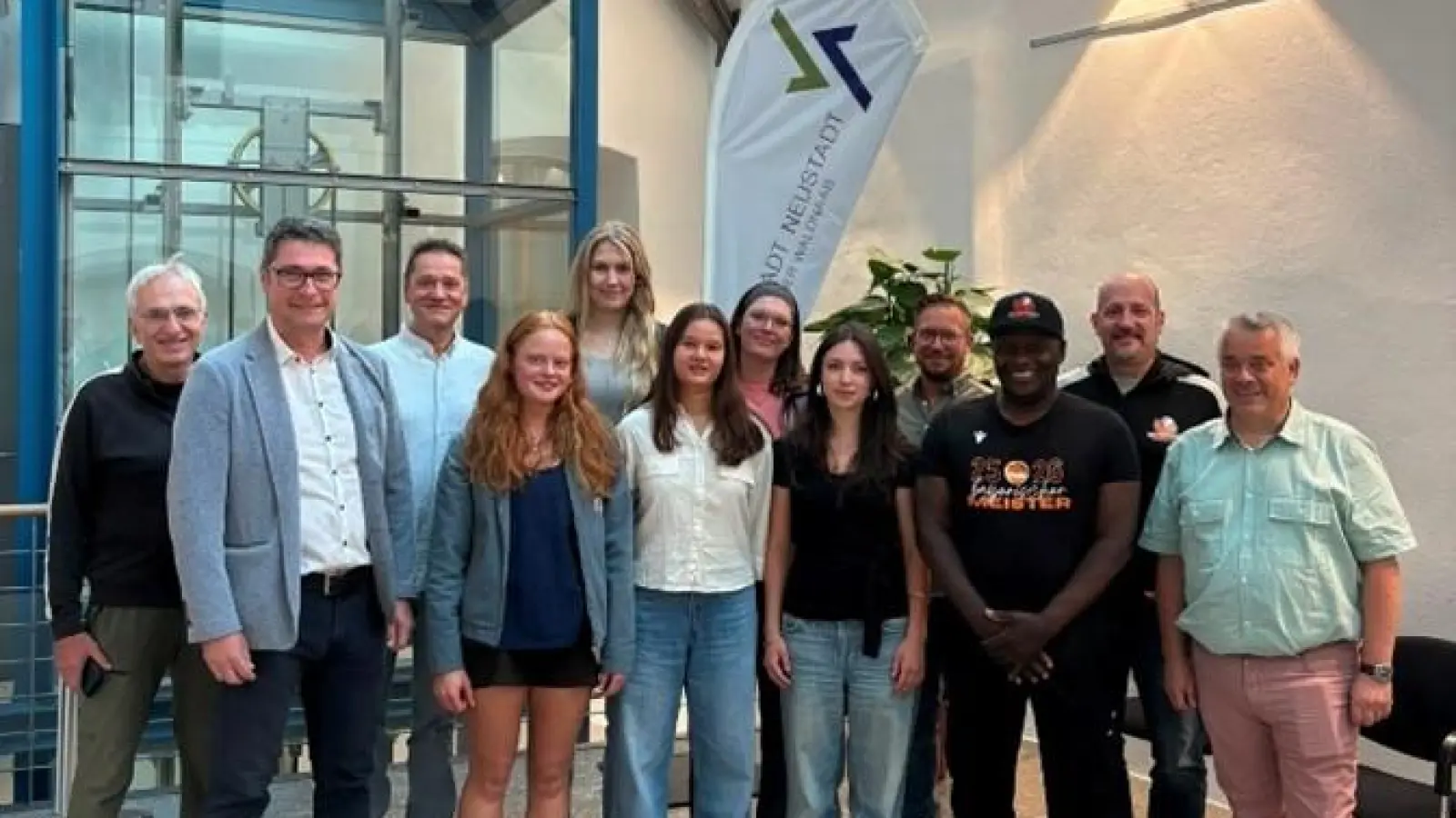 1. Vorsitzender des DJK Neustadt Basketball Willi Merkl, Zweiter Bürgermeister Armin Aichinger, Stadtrat Thomas Hauer, die U20 – Basketballerinnen, Sportreferent Stefan Linsmeier, Trainer William Earl Nesbitt und Chris Sardgon sowie Dritter Neustädter Bürgermeister Stefan Hausdorf bei den kleinen Feierlichkeiten im Rathausfoyer (v.l.n.r.). (Bild: Julia Fienz)