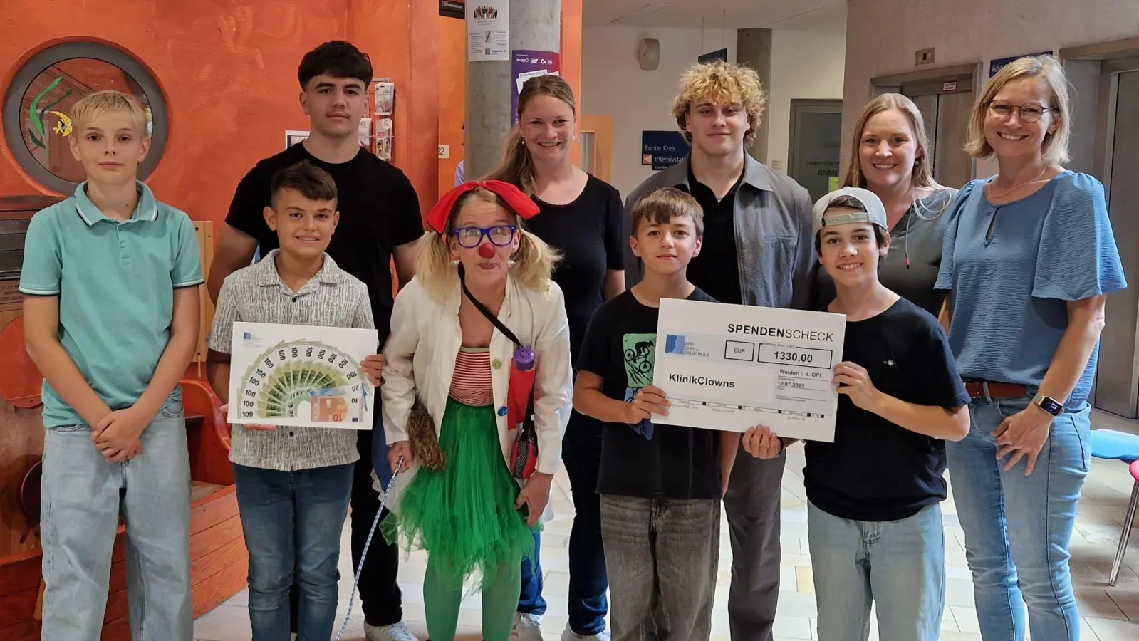 Schüler und Lehrkräfte übergaben einen Scheck an die KlinikClownin. (Bild: Stefanie Müller)