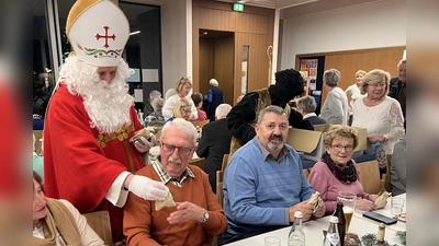 Nikolaus (Gemeindereferent Markus Seefeld) mit Knecht Ruprecht (Max Haseneder), Engelchen (Silvia Beck) und Seniorenbeauftragte Gabriele Beck beim Austeilen der Säckchen und das neue Seniorenprogramm 2026 an alle Senioren.  (Bild: Silvia Beck)