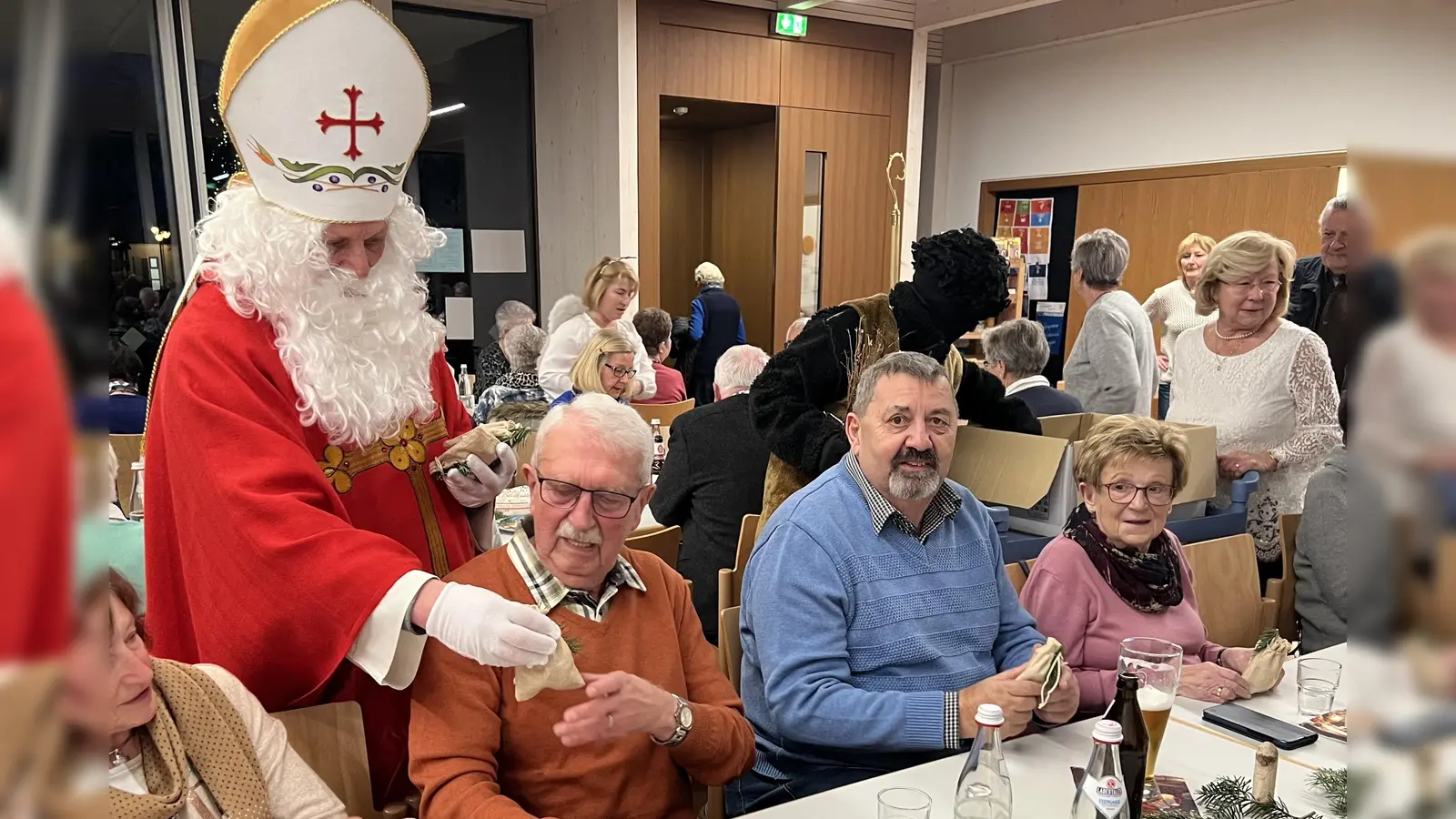 Nikolaus (Gemeindereferent Markus Seefeld) mit Knecht Ruprecht (Max Haseneder), Engelchen (Silvia Beck) und Seniorenbeauftragte Gabriele Beck beim Austeilen der Säckchen und das neue Seniorenprogramm 2026 an alle Senioren.  (Bild: Silvia Beck)
