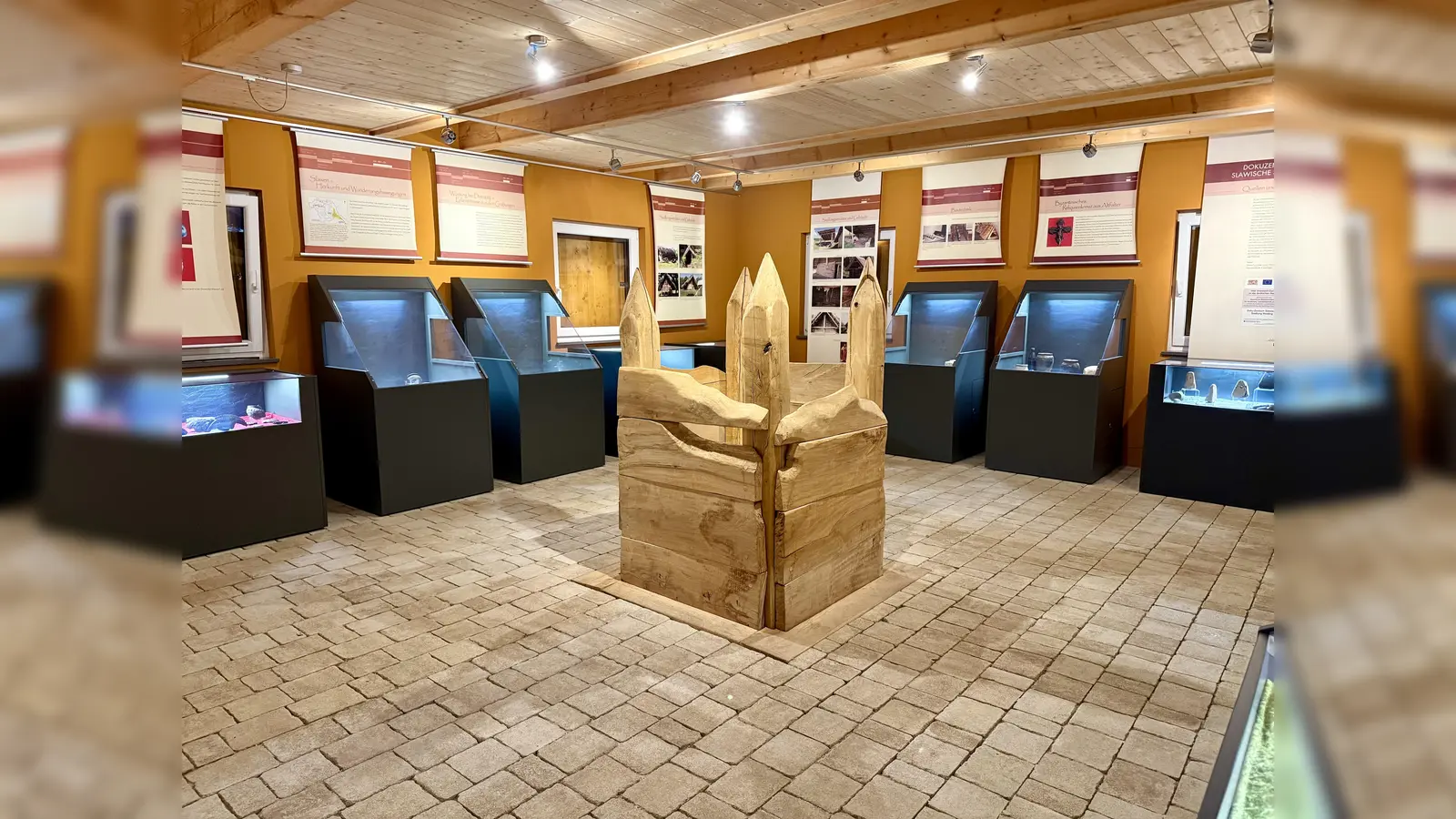 Ausstellungsraum im Dokuzentrum Slawische Besiedlung in Weiding mit einem rekonstruierten Holzbrunnen und Originalfunden in den Schaukästen. (Bild: Thomas Fritsch)