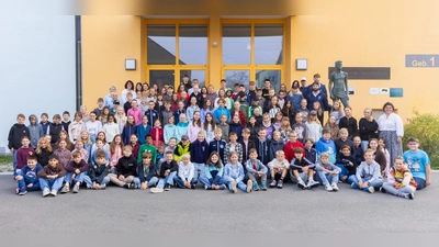Die neuen Fünftklässlerinnen und Fünftklässler mit ihren Klassenlehrkräften, Tutoren und Schulleiterin Irene Sebald (stehend, ganz rechts) sowie Niklas Postel, Luca Gläser und Tommy Muck von den Blue Devils Weiden. (Bild: Tobias Neubert)