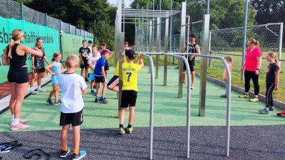 Egal, ob an den Stangen oder mit dem Körpergewicht: Die Übungen machten nicht nur Spaß, sondern gingen auch auf die Muskeln. Mit Unterstützung von Bodylates- Coach Sandra Pittner (links) probierten die Kinder und Jugendlichen die neue Calsithenics- Anlage in Vorbach beim FWG- Kinderferienprogramm aus.  (Bild: Dominik Eckert)