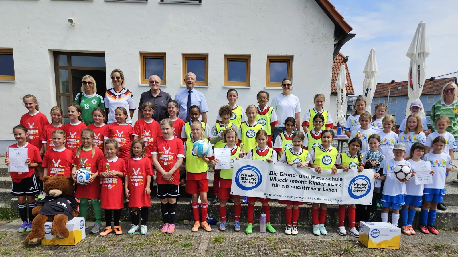 Die drei Mädchen-Mannschaften nach der Landkreismeisterschaft der Grundschulen auf dem Sportgelände des FV Vilseck von links: 1. Poppenricht, 2. Vilseck und 3. Auerbach mit (hinten, von links) Susanne Engelhardt und Rektorin Janina Schmidt (beide Poppenricht), Karl Heinz Grollmisch, Günter Simmerl, Lehrerin Julia Kroher (Vilseck) und Lehrerin Sabine Biersack (Auerbach). (Bild: Christine Grollmisch)