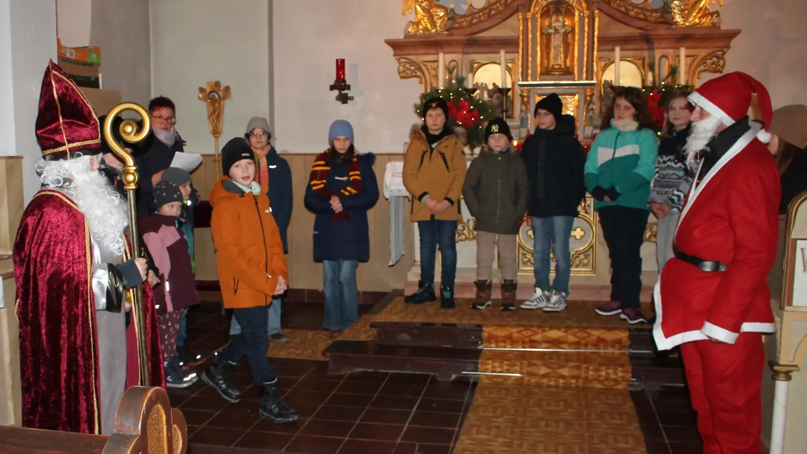 Festtagskommerz auf der ganzen Linie: Davon hielten die Zessauer und Weihersberger „Kids” in ihrem Krippenspiel gar nichts und jagten am Ende sogar den Ho-ho-ho-Weihnachtsmann (rechts) als „billige Kopie” des mildtätigen Bischofs Nikolaus aus dem Altarraum. (Bild: Bernhard Piegsa)