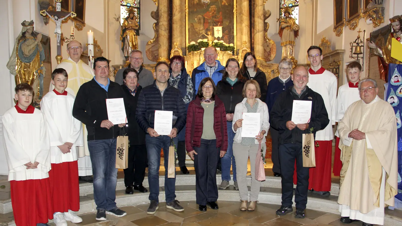 Die verabschiedeten PGR-Mitglieder (mit Urkunde, von links) Martin Martzak, Peter Kirchhammer, Lisa Fischer, Alfons Wittmann, nicht im Bild Sylvia Mathes; dahinter die aktuellen PGR-Mitglieder (von links) Monika Stepper, Andreas Niederalt (neu) Claudia Böhm, Alois Fronhofer, Michaela Müller, Diana Portner (neu), nicht im Bild Doris Prey (neu); PGR-Sprecherin Irmgard Glaser (vorne, Mitte), Pfarrer Herbert Rösl (links), Pfarrer Max Stigler (rechts) sowie der liturgische Dienst. (Bild: Josef Böhm)