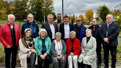 Zur feierlichen Aufstellung der Partnerschaftsbank kamen neben Wunsiedels Erstem Bürgermeister Nicolas Lahovnik (stehend, fünfter von links) auch Schwarzenbergs Oberbürgermeister Ruben Gehart (stehend, dritter von links), Vertreterinnen und Vertreter der Seniorenvertretung Wunsiedel, Mitarbeiter der beiden Bauhöfe sowie die Vorsitzende des Partnerschaftsvereins SOL, Inge Schuster (sitzend, ganz rechts), zusammen. (Bild: Kristina Wiedel)