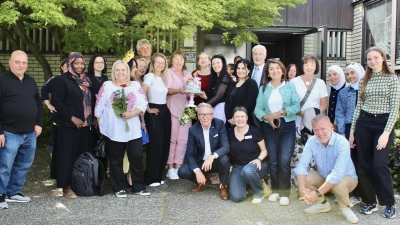 Feierliche Bewirtung mit Festtagstorte vor dem evang. Gemeindezentrum mit Stadträt:innen: Reinhold Wildenauer (3. Bürgermeister) sitzt vorne, Sema Tasali-Stoll (SPD) vorne rechts, daneben rechts Brigitte Schwarz (SPD), im Hintergrund rechts Reinhard Meier (Bürgerliste). (Bild: Nataliia Branopolska )