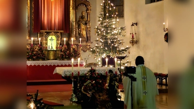 Pfarrvikar Robert vor dem festlich geschmückten Altar und der Krippe zum Abschluss der Christmette. (Bild: Beate Suttner)