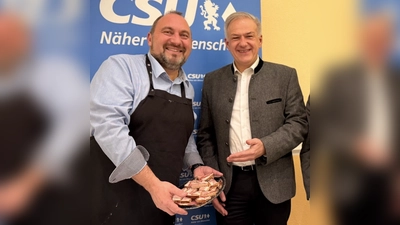 Auch dem Landrat Roland Grillmeier bietet Bürgermeisterkandidat Oliver Becher eine Stärkung an. (Bild: Johannes Koller)