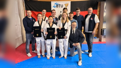 Das Bild zeigt die drei Prüflinge mit den Trainern und den mitgereisten Unterstützern (Bild: Jürgen Brand)