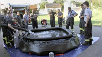 Im Beisein von Bürgermeister Martin Prey (Fünfter von links) testeten die Aktiven der Niedermuracher Feuerwehr den neuen Faltbehälter. Thomas Pirzer schaffte mit seinem Vakuumfass das Löschwasser herbei. (Bild: Josef Böhm)