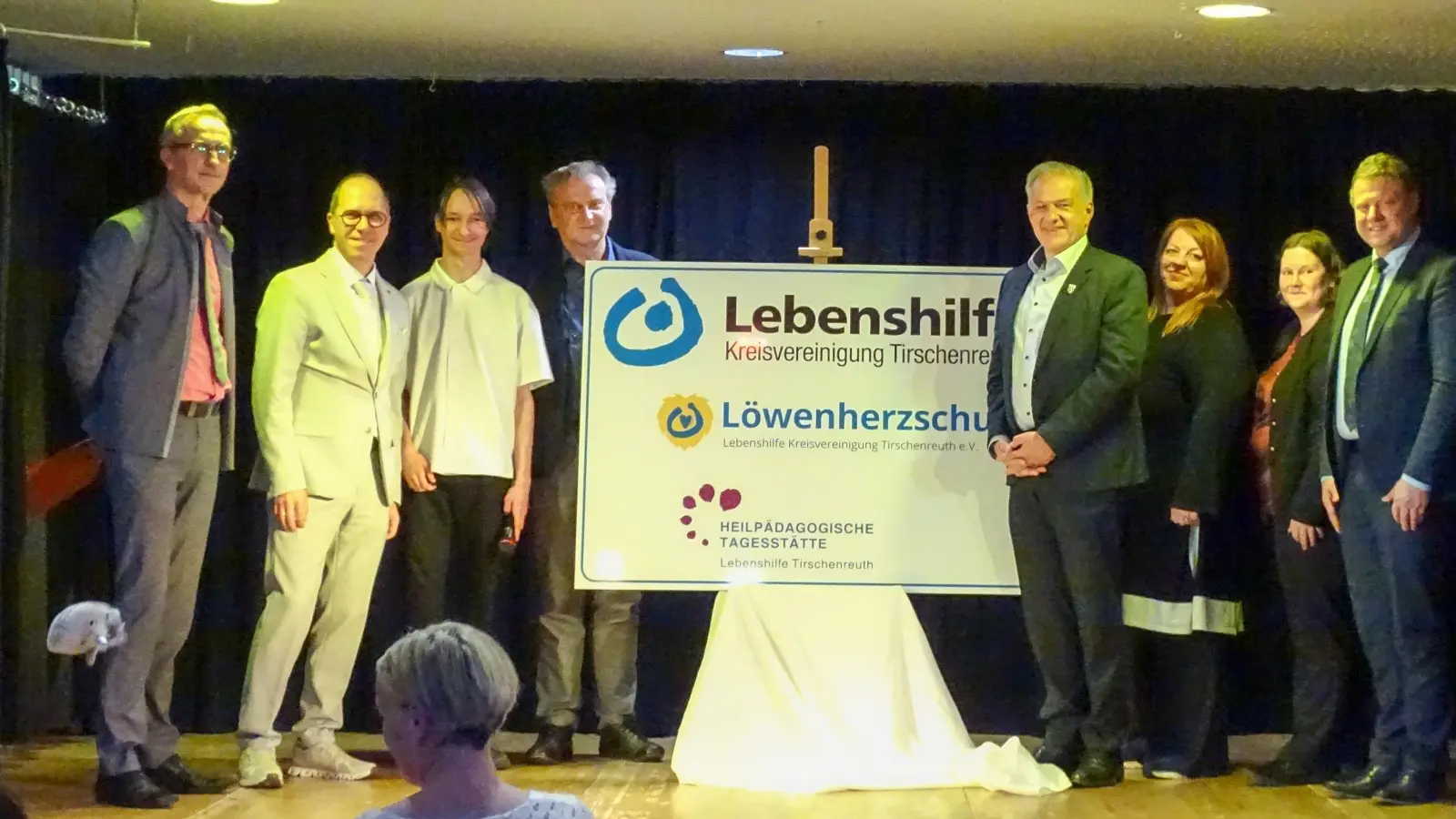 Der neue Schulname wird enthüllt mit Schulleiter Klaus Jahn, Stefan Fricker (Regierung der Oberpfalz), Schülersprecher Jeremy K., Geschäftsführer Berthold Kellner, Vorsitzender Roland Grillmeier, HPT-Leitungen Sandra Köstler und Christina Ponader und Stefan Grillmeier. (Bild: Kathrin Krieger)