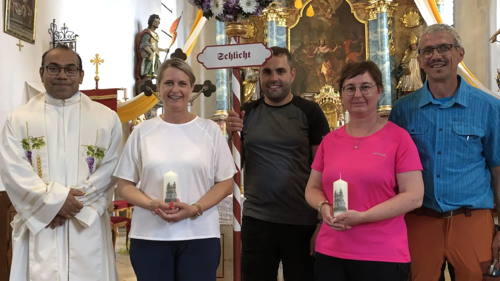 Bereits in der Basilika Gößweinstein wurden nach dem Wallfahreramt für ihre „Jubiläums-Teilnahme“ Simone Graf (links) für 20 und Regina Leonhard für 10 Wallfahrten mit einer Urkunde ausgezeichnet und in Schlicht erhielten sie von Pilgerführer Edmund Heldmann die neugestaltete Kerze. Dazu gratulierten auch Pater Jimmy Joseph und Wallfahrtsbild-Träger Stefan Wismeth.  (Bild: Christian Trummer)