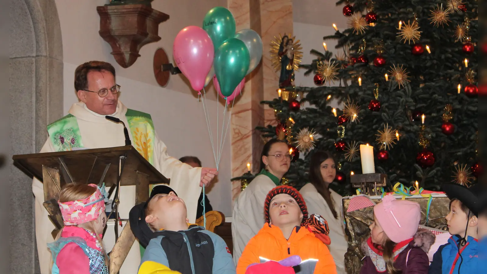 Pfarrer Hösl erklärt den Kindern mit Hilfe von bunten Ballons den Text des Evangeliums (Bild: Ursula Zimmermann)