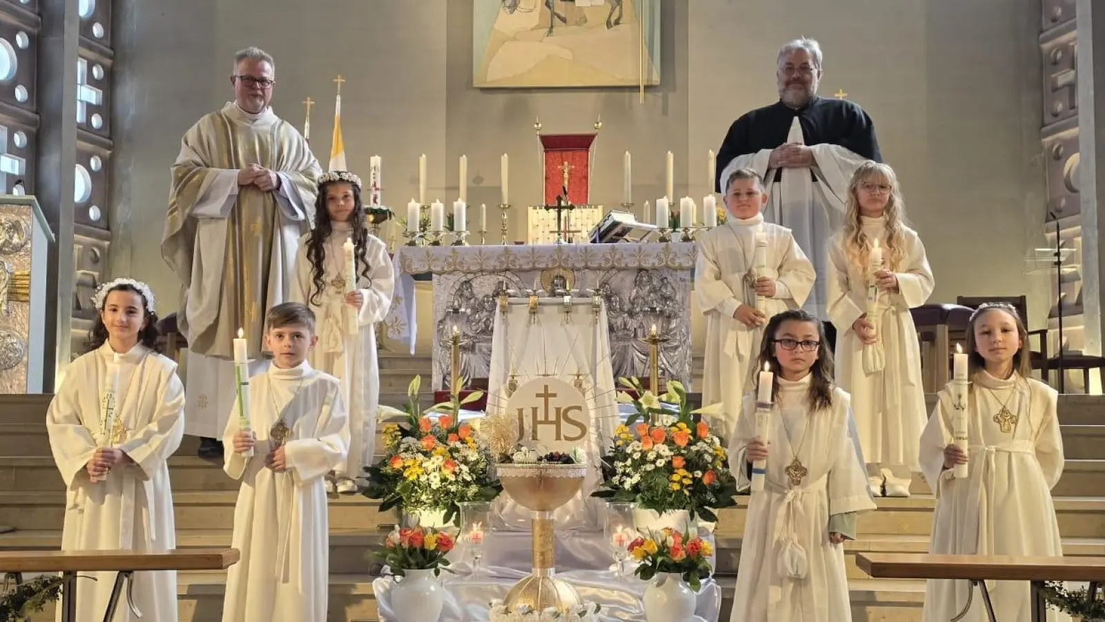 Die Erstkommunionkinder der Pfarrei Hl. Familie mit Pfarrer Maciej Kolanowski (l.) und dem Religionspädagogen und Pfarrgemeinderatssprecher Carsten-Armin Jakimowicz (r.) (Bild: Niklas Giedl)