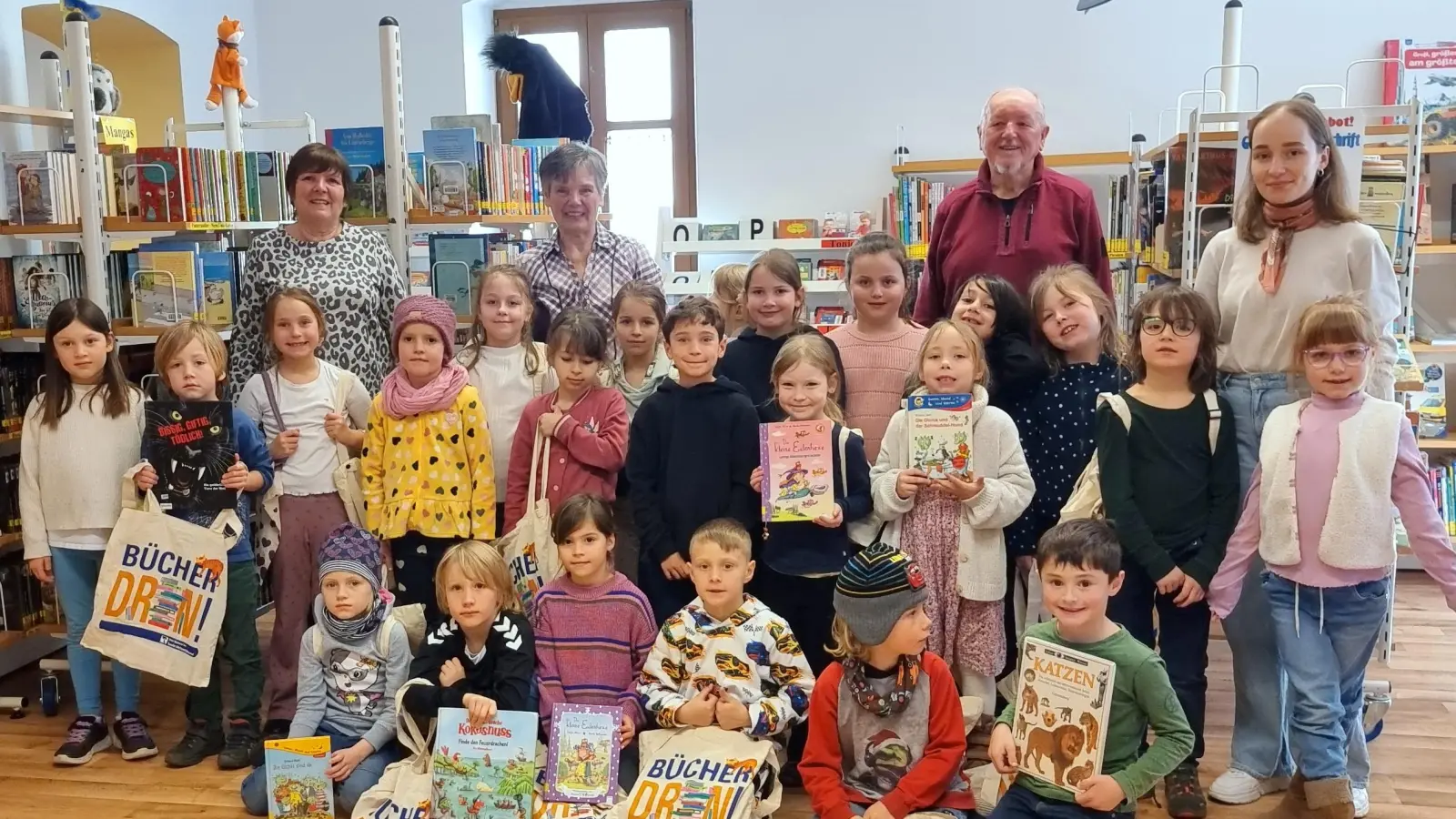 - Kinder mit ihren Büchern und Taschen, v. r. Klassenlehrerin Caroline Übler, Büchereileiter Georg Dürr, Stellv. Büchereileiterin Christa Kastner und Mitarbeiterin Sabine Diener (Bild: Georg Dürr)