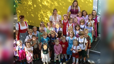 Zum „Tag der Tracht“ kamen viele Mädchen und Buben des St. Wolfgang-Kindergarten in Lederhosen oder im Dirndl in den Kindergarten. Das taten auch die stellvertretende Leiterin Katrin Noßner (hinten Mitte) sowie die Erzieherinnen Martina Dolles (links) und Nicole Korent (rechts). (Bild: Werner Schulz)