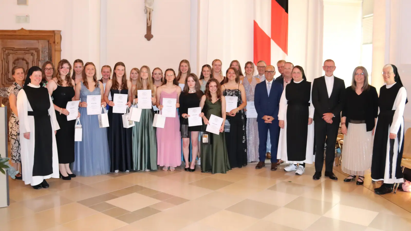 Die besten Abschlussschülerinnen mit einer Eins vor dem Komma zusammen mit Schulleiterin Kerstin Reiter (2. von rechts), den Klassenleiterinnen Frau Hartung und Frau Schulze (hintere Reihe 1. und 2. von links) und den Ehrengästen (von rechts ab dem 3. von rechts: Dekan Dr. Thomas Vogl, Sr. M. Sophia Schlembach, Elternbeiratsvorsitzender Alexander Wurm, Fördervereinvorsitzender Dr. Achim Nemsow, stellvertretender Landrat Dr. Alfred Scheidler und 1. Bürgermeister Bernd Sommer) : Die beiden Schulbesten mit einem Schnitt von 1,08 sind aus der Klasse 10a Sarah Meyer und Magdalena Härtl (1. Reihe 2. und 3. von links). (Bild: Gerhard Skupin)