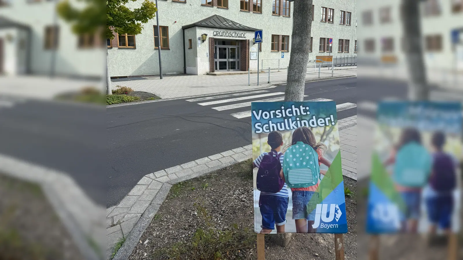 Eines der zahlreichen in Waldsassen aufgestellten Plakate vor der Waldsassener Grundschule (Bild: Nico Sommerer)