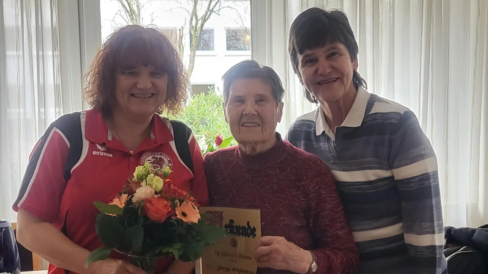 Mit einem Blumenstraß und der Ehrenurkunde für über 70 Jahre Vereinsmitgliedschaft bedankt sich die 2.Vorsitzende des TB Jahn Wiesau Susanne Weiser (links) bei Marga Weigl (Mitte). Mit im Bild Nachbarin Waltraud Konrad (rechts) (Bild: Susanne Weiser)